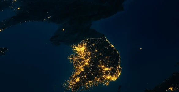 península coreana vista desde el espacio durante la noche, con Corea del Sur completamente iluminada y Corea del Norte en gran parte oscura. Representación visual del contraste tecnológico y económico dejado por la guerra de Corea.