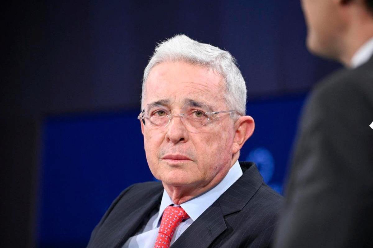 Álvaro Uribe Vélez durante un evento público, vistiendo traje oscuro y corbata roja, en el contexto de la tutela que confirmó su libertad