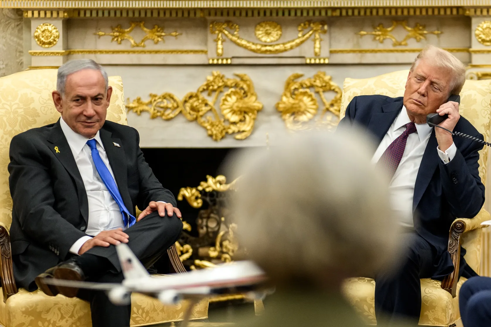 El presidente Donald Trump conversa por teléfono en la Casa Blanca mientras el primer ministro israelí Benjamin Netanyahu lo acompaña en una reunión, en el marco de la presentación del plan de paz de Trump para Gaza