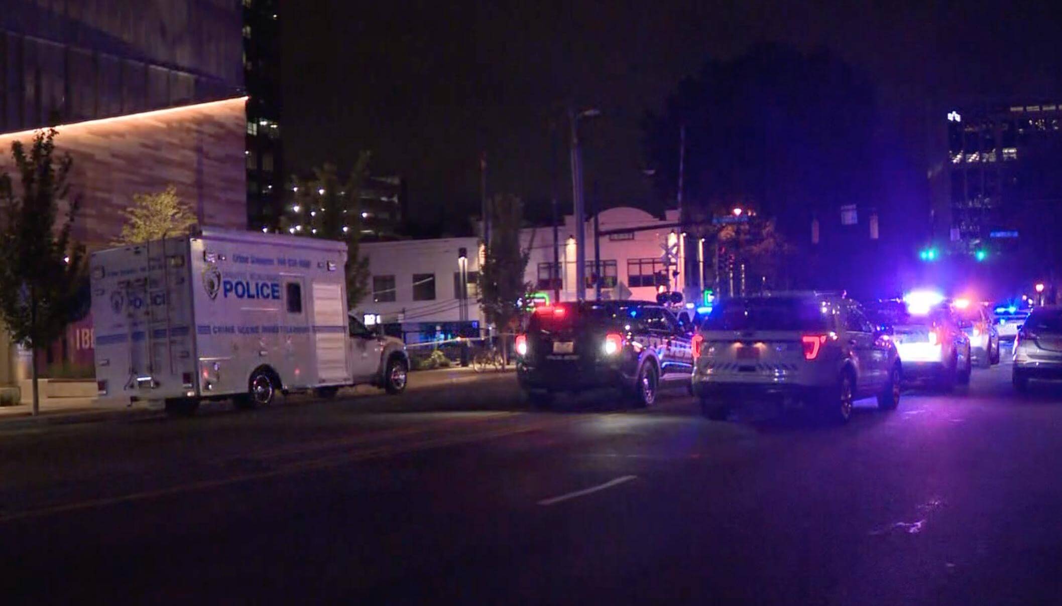 Escena nocturna frente a una estación en Charlotte con fuerte presencia policial, patrullas y vehículos de investigación iluminando el área tras el asesinato en Charlotte