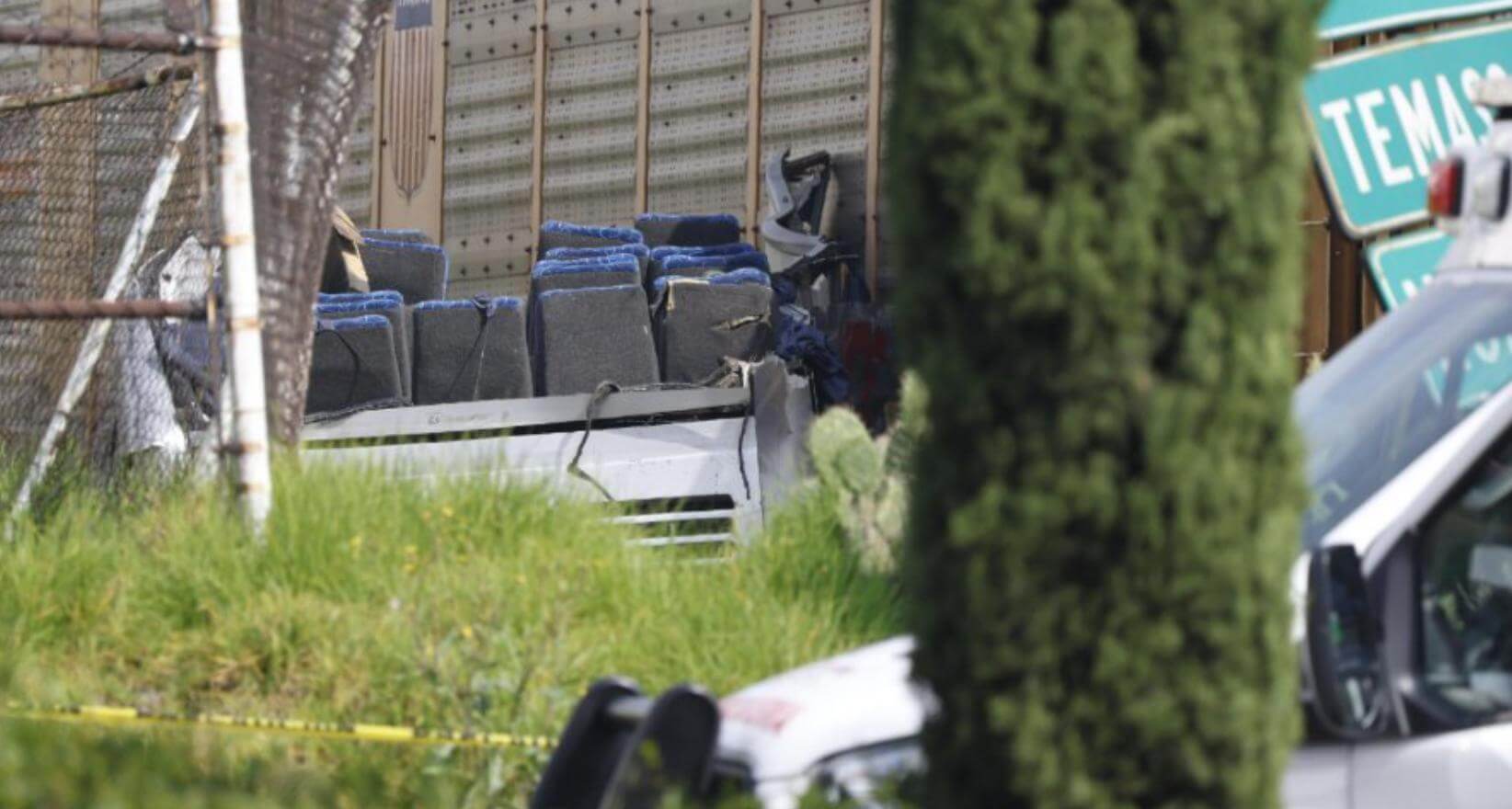Restos del autobús partido en dos tras el accidente en Atlacomulco, con asientos expuestos junto al tren de carga. Escena del accidente en la carretera Atlacomulco-Maravatío