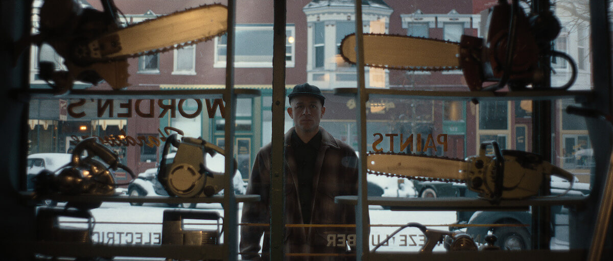Charlie Hunnam como Ed Gein observando motosierras en una vitrina de ferretería en Monster: la historia de Ed Gein, serie de Netflix