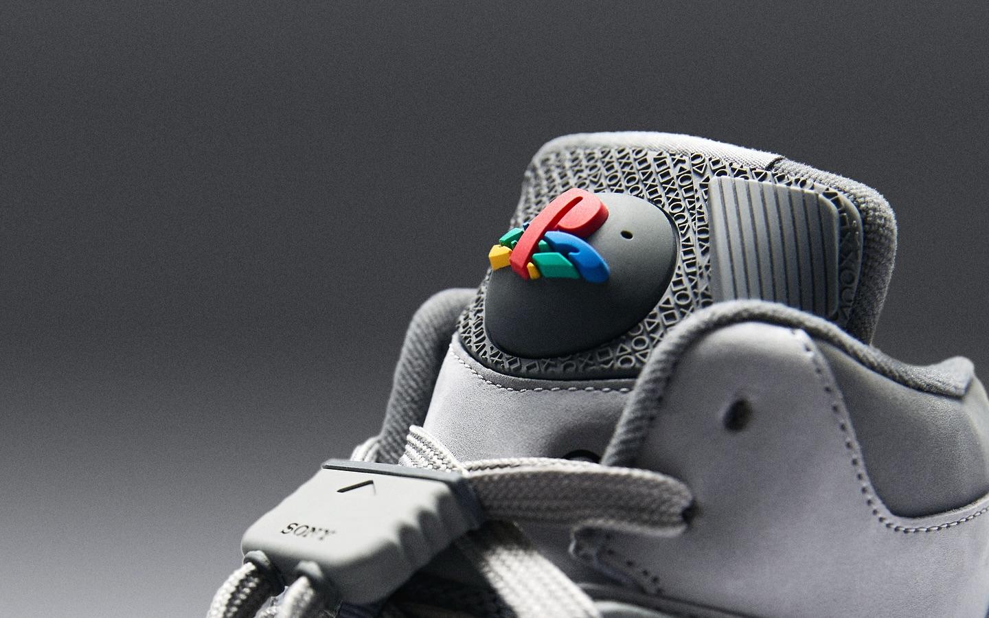 Detalle de un tenis gris de la colección PlayStation x Reebok con el logotipo clásico de PlayStation en colores, conmemorando los 30 años de PlayStation