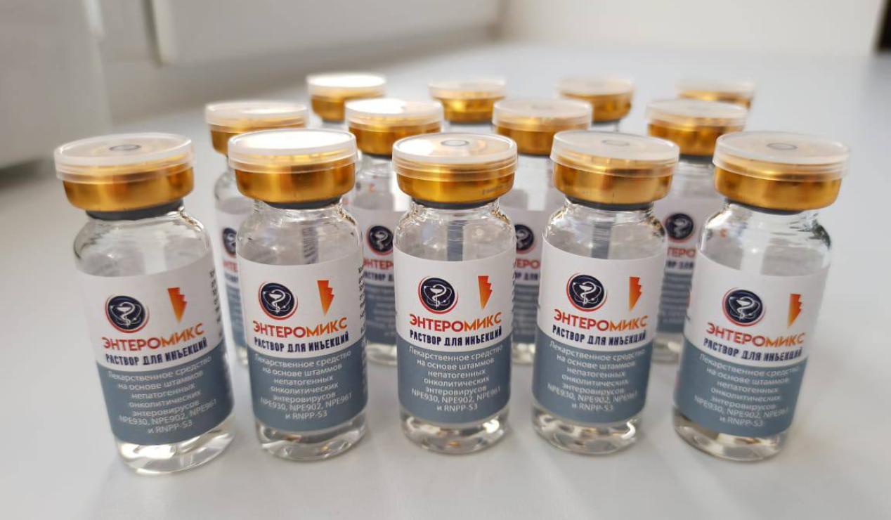 Viales de la vacuna rusa contra el cáncer EnteroMix alineados sobre una mesa, con tapas doradas y etiquetas en ruso visibles en primer plano