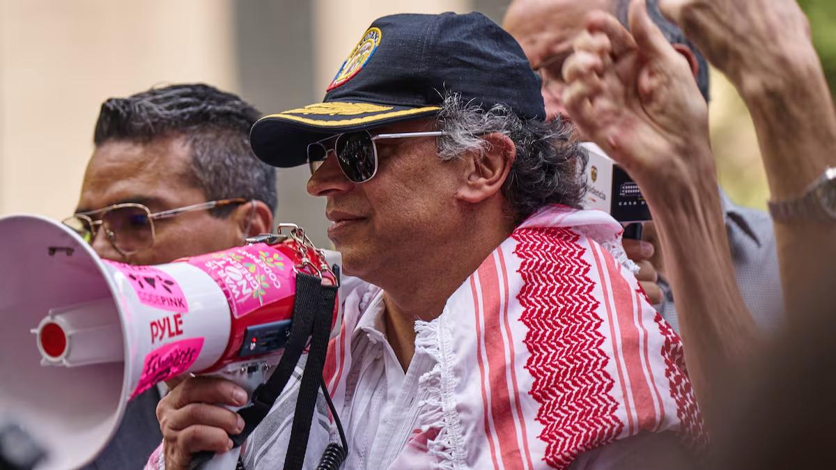 Gustavo Petro con bufanda rosada y blanca y megáfono en mano durante la protesta en Nueva York que derivó en la revocación de la visa de Gustavo Petro