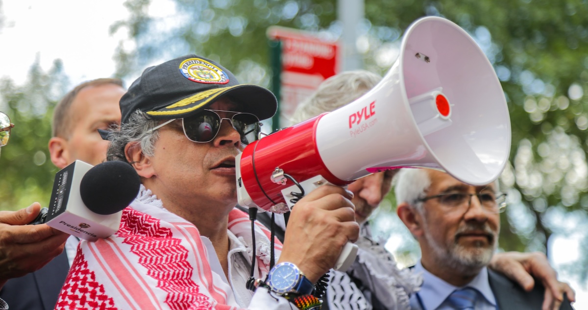Gustavo Petro con bufanda rosada y blanca y megáfono en Nueva York durante el discurso que llevó a la revocación de la visa de Gustavo Petro