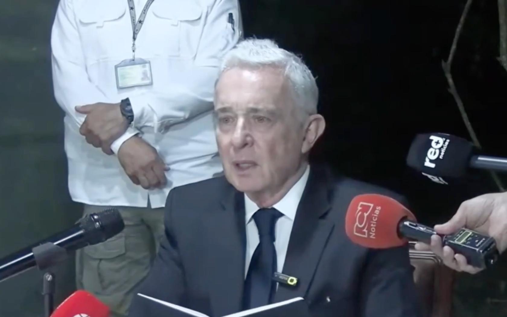 Álvaro Uribe Vélez ofrece un comunicado ante los medios de comunicación, con varios micrófonos frente a él, en el contexto del mensaje de Álvaro Uribe tras su absolución