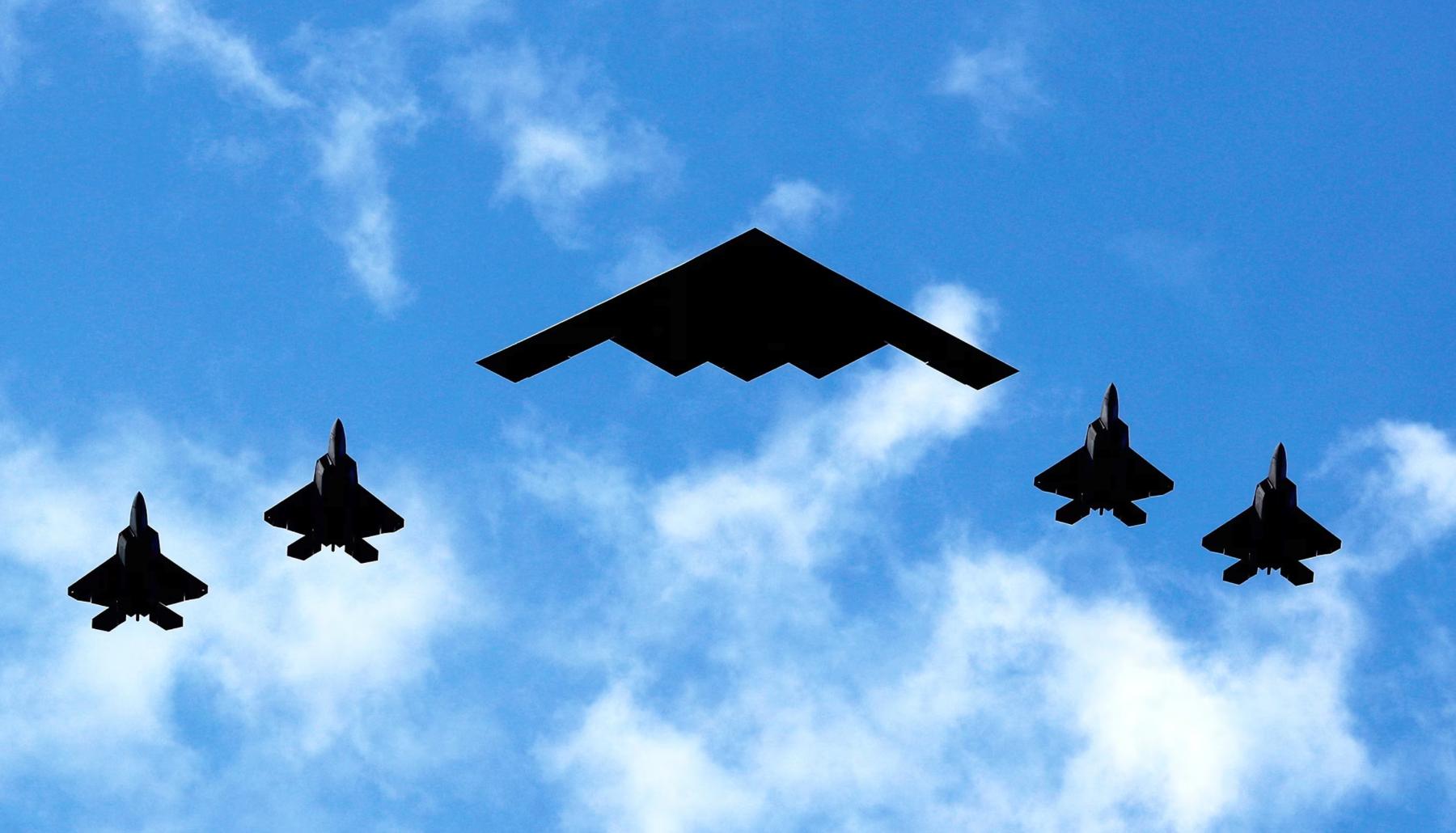 Bombardero furtivo B-2 escoltado por cazas F-35 volando sobre un cielo despejado, símbolo de los bombardeos en Irán mencionados por el presidente Trump