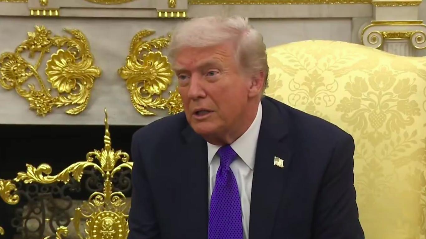 Primer plano del presidente de Estados Unidos durante una declaración oficial en un salón con decoración dorada; gesto serio mientras responde preguntas — Trump amenaza a Gustavo Petro