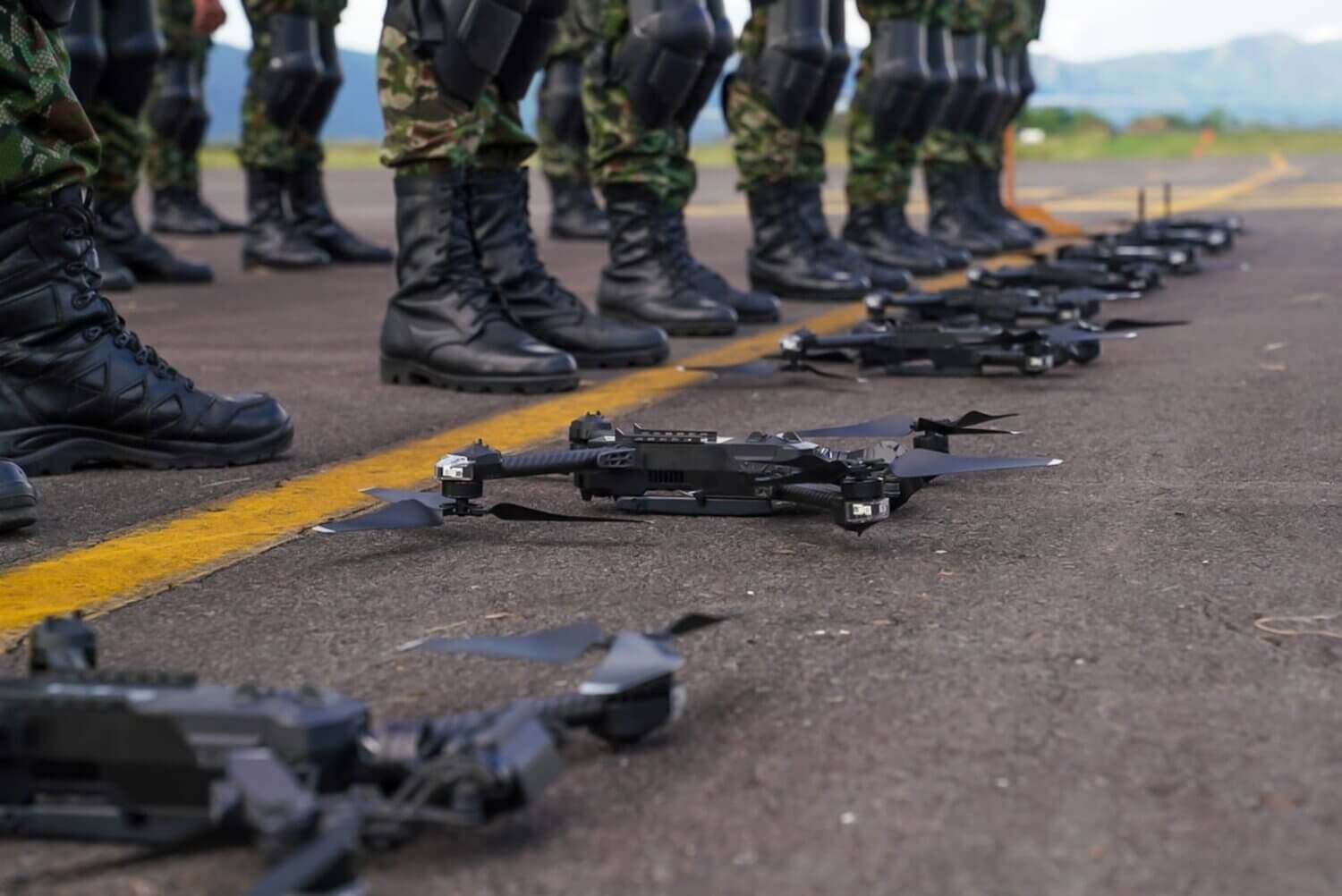 Filas de drones tácticos alineados sobre el asfalto frente a soldados del Ejército de Colombia, durante el entrenamiento del nuevo batallón de drones