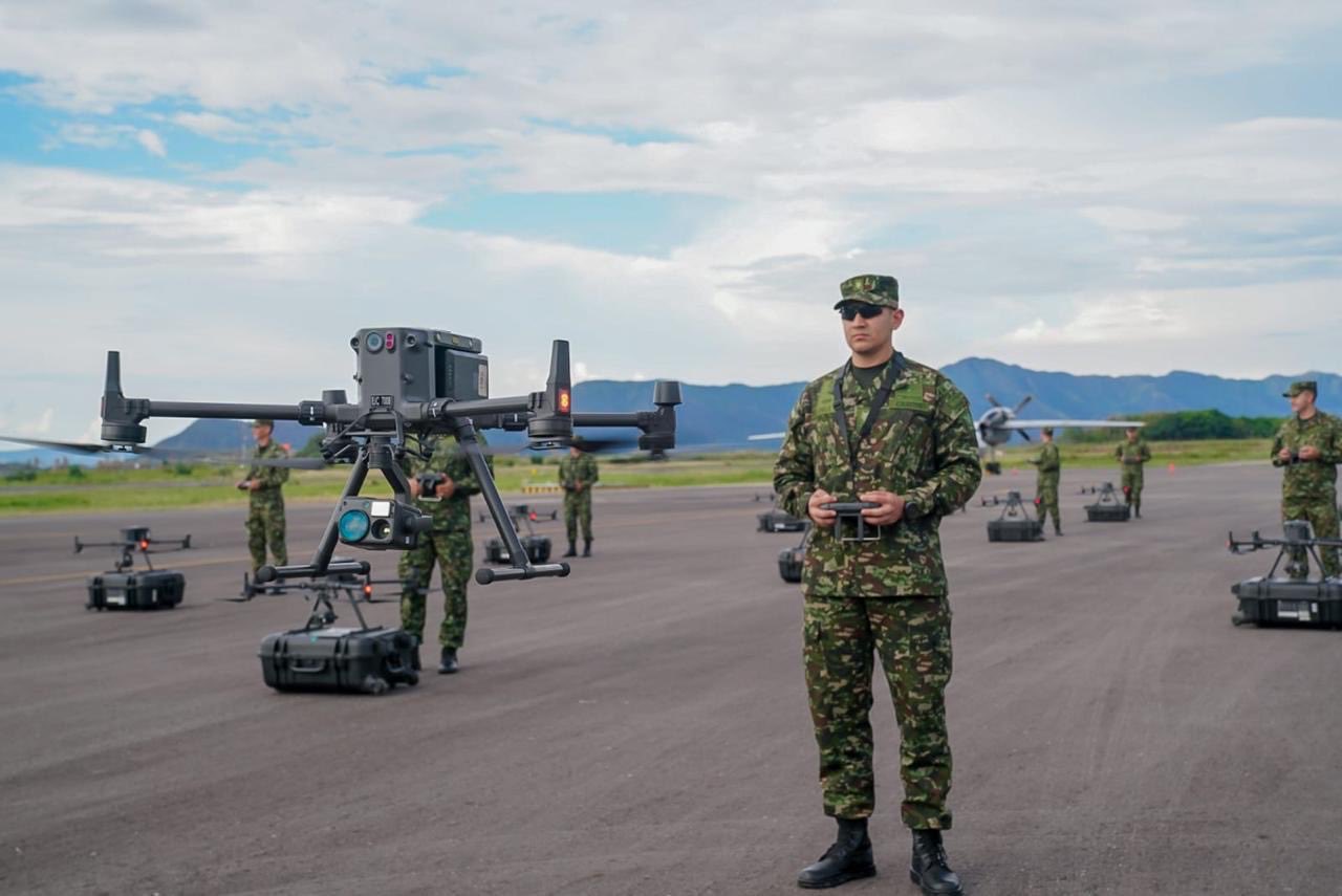 Soldados del Ejército de Colombia operan un dron de gran tamaño durante el entrenamiento del nuevo batallón de drones en una pista militar, con montañas al fondo y equipos listos para el despegue