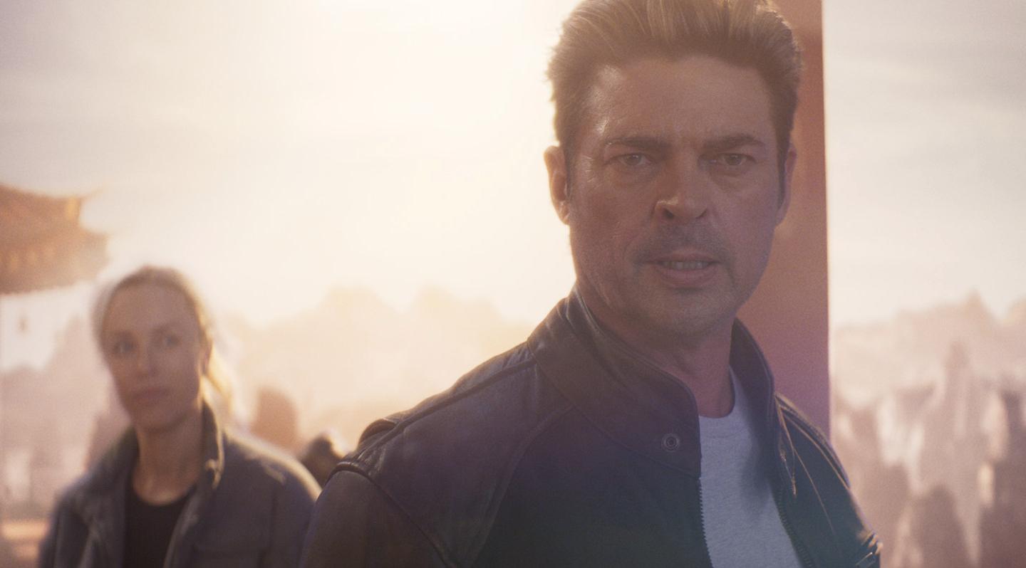 Karl Urban en primer plano caracterizado como Johnny Cage, con expresión seria y fondo difuminado, representando la nueva fecha de estreno de Mortal Kombat 2