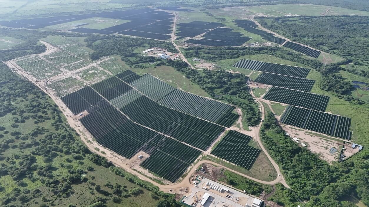 Vista aérea del parque solar Guayepo III en Ponedera, Atlántico, con cientos de filas de paneles solares rodeados de vegetación, representando el avance del proyecto hacia una matriz energética limpia en Colombia