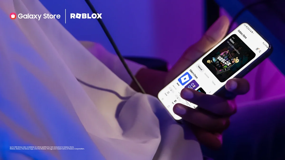 Una persona sostiene un teléfono Samsung Galaxy con la pantalla mostrando Roblox en la Galaxy Store, ilustrando la llegada de Roblox en Samsung y Xbox Ally