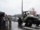 Soldados observan un vehículo militar inspirado en el Warthog de Halo durante una exhibición en un estacionamiento, en alusión simbólica al fin de la guerra de consolas