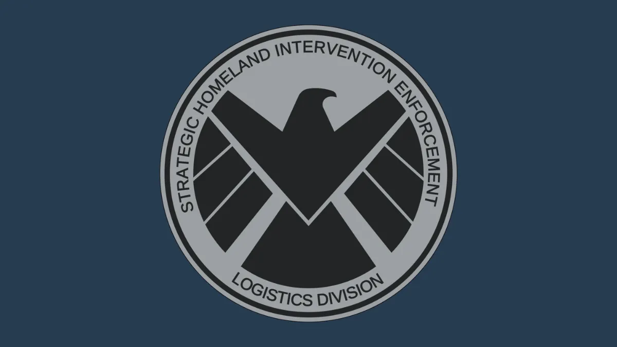 Logotipo ficticio de la agencia S.H.I.E.L.D. del universo Marvel. Muestra un águila estilizada en color negro dentro de un emblema circular gris con las palabras “Strategic Homeland Intervention Enforcement Logistics Division” alrededor. El fondo es azul oscuro