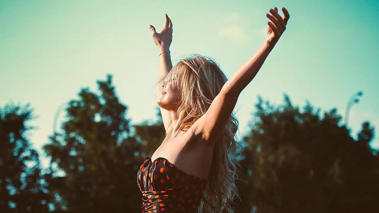 Mujer alzando los brazos hacia el cielo en un gesto de libertad durante la Semana Anticomunista