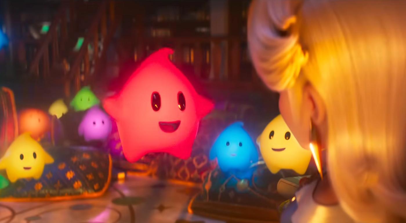 Escena de Super Mario Galaxy donde varios Lumas de colores flotan frente a una figura femenina de espaldas, iluminados por tonos cálidos en un ambiente cósmico