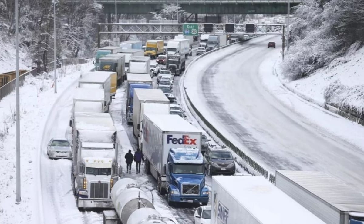 Fila de camiones y autos detenidos en una autopista cubierta de nieve en Estados Unidos, mostrando el impacto de los choques múltiples por la tormenta invernal en Estados Unidos