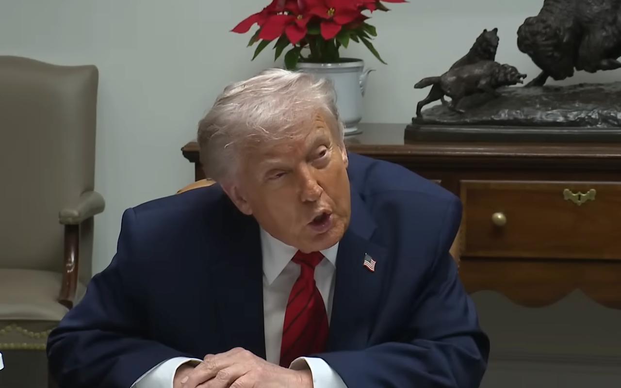 l presidente estadounidense Donald Trump aparece sentado durante una intervención pública, inclinándose hacia adelante mientras gesticula, en el momento en que afirma que Petro será el siguiente, con un adorno navideño y una escultura en el fondo