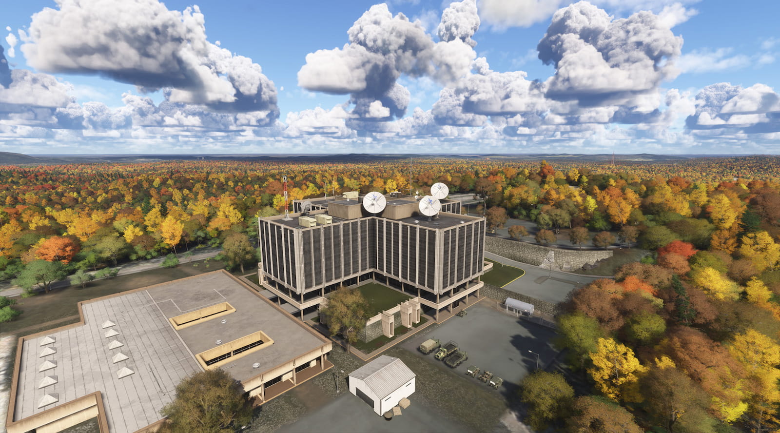 Vista aérea del complejo del Laboratorio Nacional de Hawkins rodeado de un extenso bosque otoñal bajo un cielo parcialmente nublado, recreado en Stranger Things en Flight Simulator